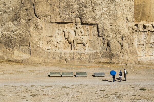 Люди рассматривают барельеф, изображающий триумф Шапура I над римским императором Валерианом и Филиппом Аравийским; Накш-э-Рустам, провинция Фарс, Иран. - Sputnik Таджикистан