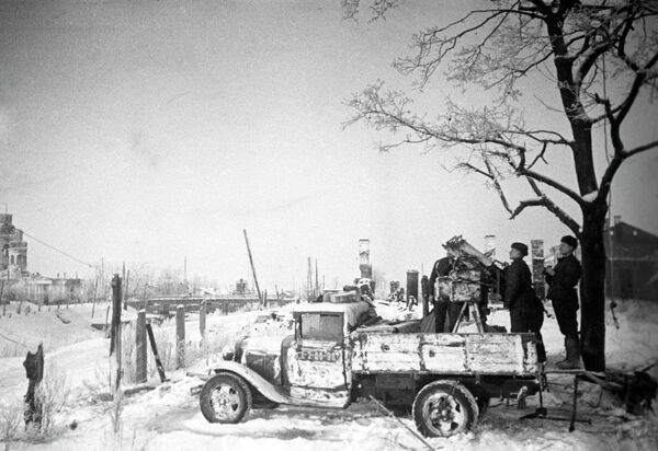 Расчет советской зенитно-пулеметной установки М4 (системы Максим) в кузове грузовика ГАЗ-АА ведет наблюдение в освобожденном Шлиссельбурге. Слева -   разрушенный Благовещенский собор. - Sputnik Таджикистан