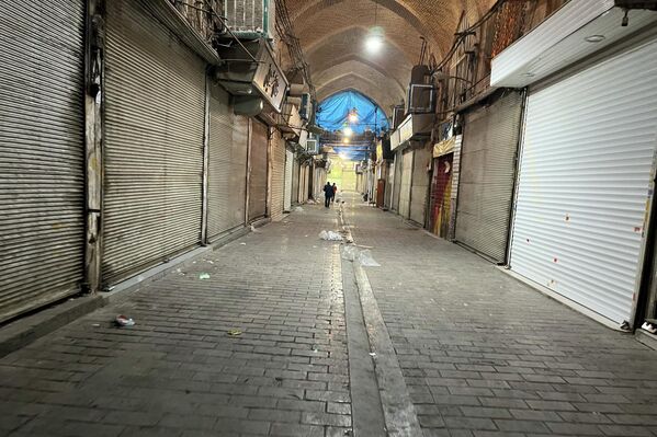 Одамон зимни эътирозҳо дар Эрон аз назди мағозаҳои баста мегузаранд. - Sputnik Тоҷикистон