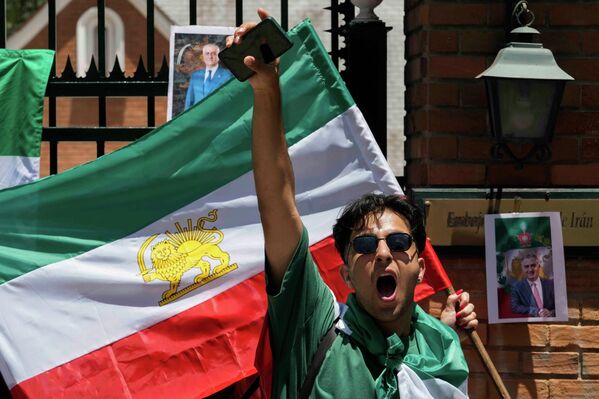 Як иштирокчии гирдиҳамоии барои пуштибонӣ аз эътирозҳо дар Эрон дар назди сафорати Эрон дар Сантяго, Чили, фарёд мезанад. - Sputnik Тоҷикистон