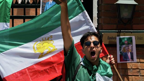 Участник митинга в поддержку протестов в Иране кричит перед посольством Ирана в Сантьяго, Чили, во вторник, 13 января 2026 года. - Sputnik Тоҷикистон