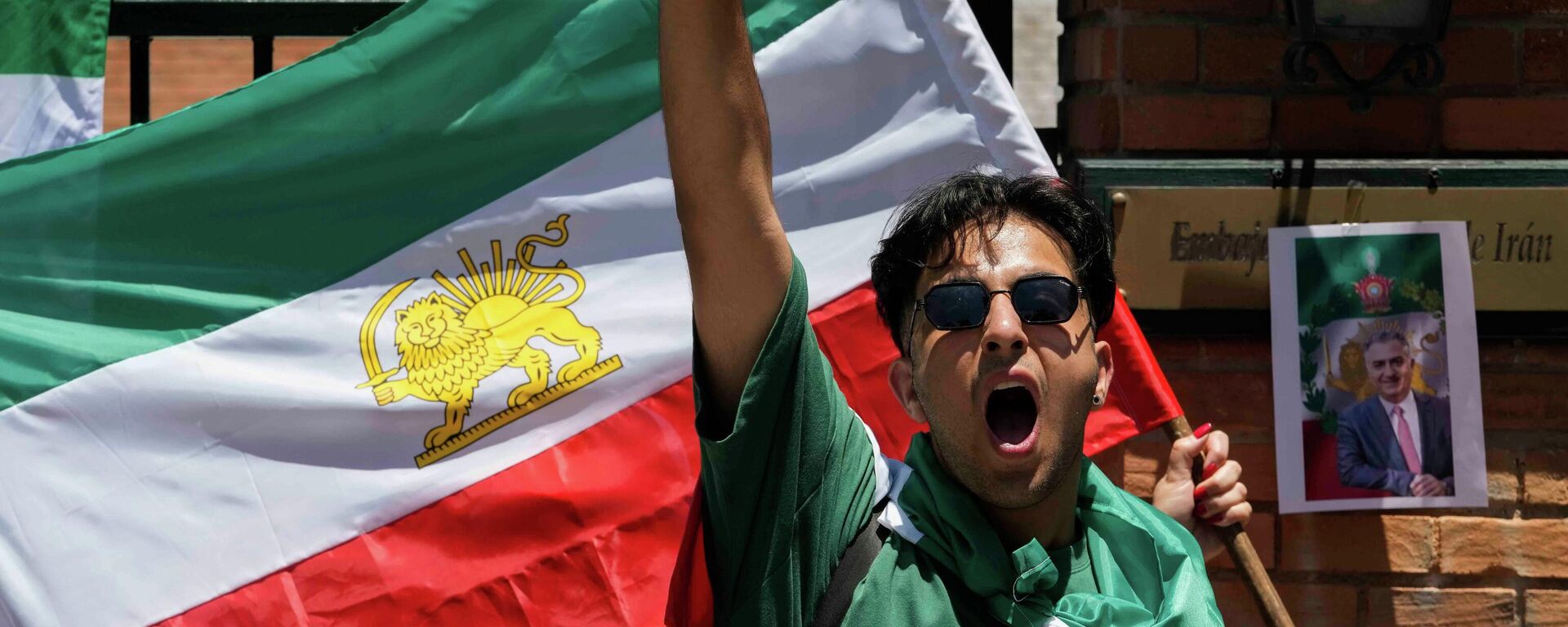 Участник митинга в поддержку протестов в Иране кричит перед посольством Ирана в Сантьяго, Чили, во вторник, 13 января 2026 года. - Sputnik Таджикистан, 1920, 14.01.2026