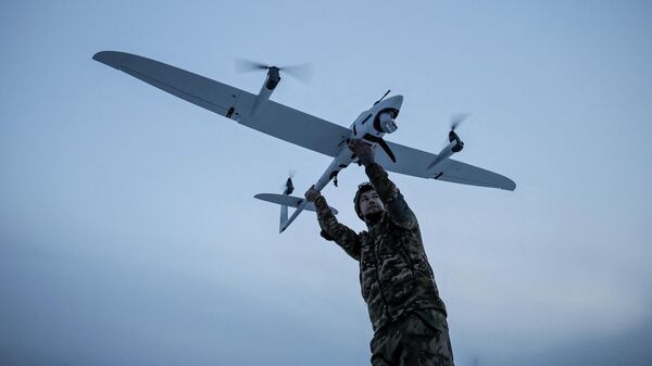 Военнослужащий 24-й механизированной бригады Вооруженных сил Украины запускает дрон в Донецкой области, 5 января 2026 года.  - Sputnik Тоҷикистон