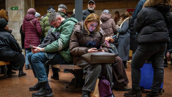 Люди укрываются в бомбоубежище на станции метро в Киеве, Украина, во вторник, 23 декабря 2025 года.  - Sputnik Тоҷикистон