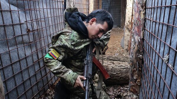Колумбийский наемник проверяет свою штурмовую винтовку в Запорожской области на Украине. - Sputnik Тоҷикистон