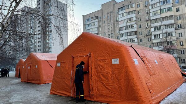 Сотрудник Государственной службы по чрезвычайным ситуациям Украины осматривает палатку правительственного пункта гуманитарной помощи в Киеве - Sputnik Тоҷикистон