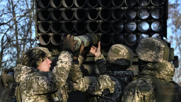 Военнослужащие 152-й егерской бригады Вооруженных сил Украины заряжают снаряд в реактивную систему залпового огня БМ-21 Град - Sputnik Тоҷикистон