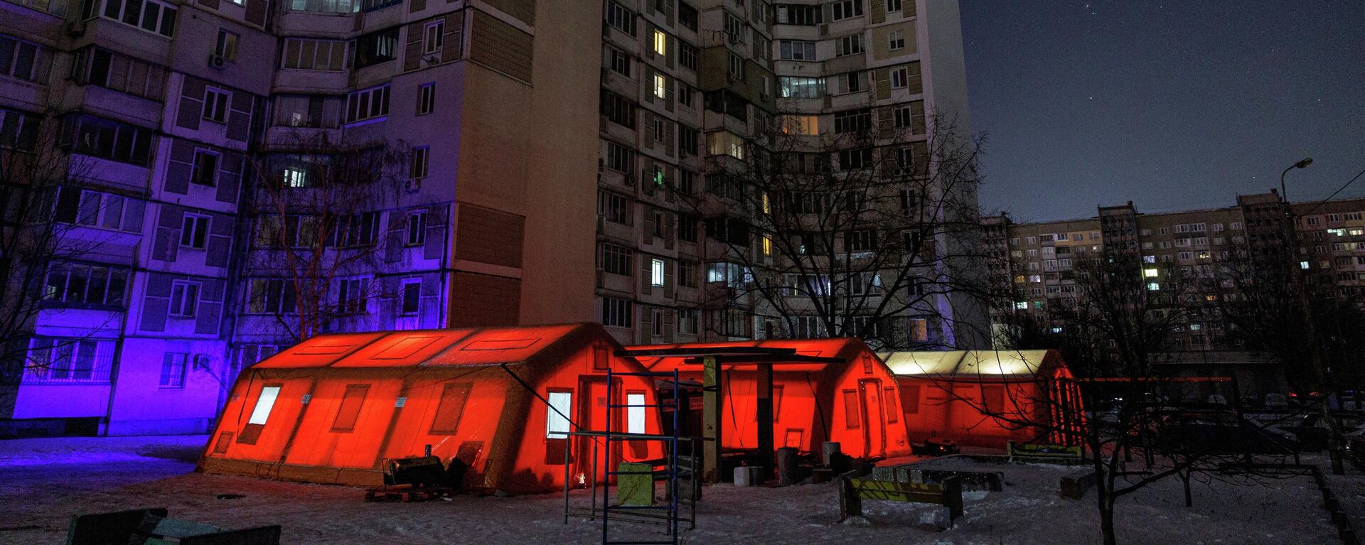 Палатки правительственного пункта гуманитарной помощи рядом с многоквартирными домами во время отключения электроэнергии в Киеве, Украина, 12 января 2026 года. - Sputnik Таджикистан, 1920, 22.01.2026