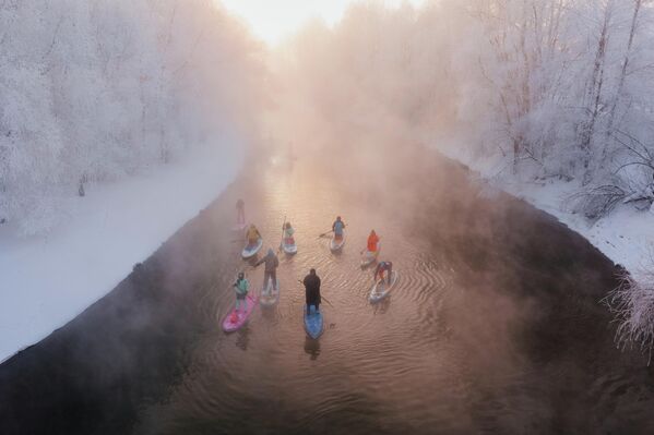 В Новосибирске люди на сапбордах плывут по одному из рукавов реки Обь, которая не замерзает даже в такие экстремальные морозы, когда температура опускается до -40°C. - Sputnik Таджикистан