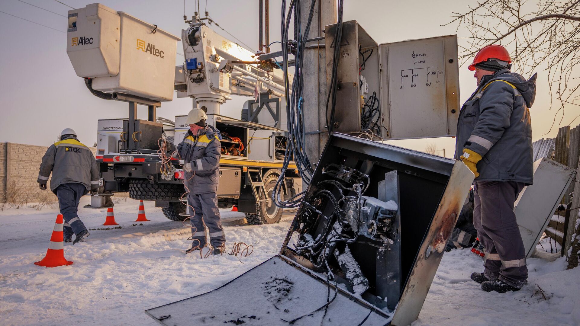 Электрики проводят аварийный ремонт опоры линии электропередачи после того, как трансформатор сгорел из-за скачка напряжения в Киевской области, Украина, среда, 14 января 2026 года. - Sputnik Таджикистан, 1920, 03.02.2026