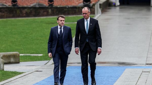 Канцлер Германии Фридрих Мерц и президент Франции Эммануэль Макрон на территории замка Олден-Бизен в день неформальной встречи лидеров Европейского союза, Бельгия, 12 февраля 2026 года.  - Sputnik Тоҷикистон