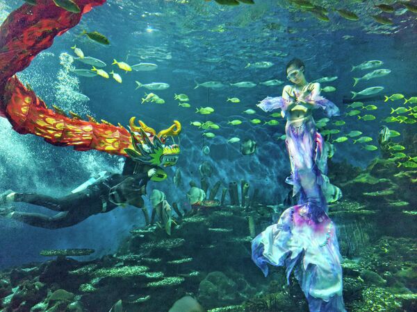 Дайвер исполняет подводный танец дракона в Уханьском океанариуме в преддверии Праздника весны. - Sputnik Таджикистан