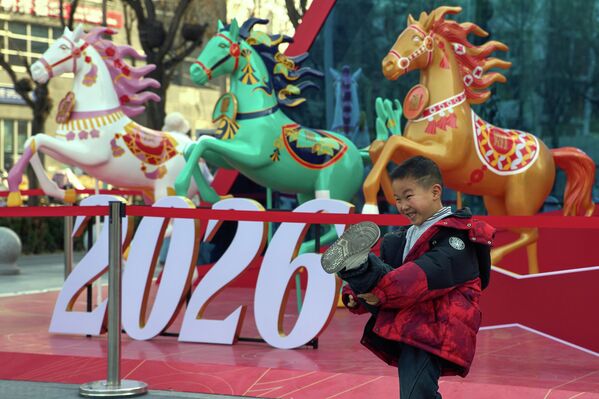 Ребенок позирует для фотографий возле украшений, установленных в преддверии китайского Нового года в Пекине. - Sputnik Таджикистан