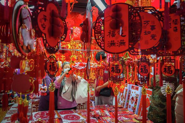 Покупатели рассматривают новогодние украшения на рынке в Пекине. - Sputnik Таджикистан