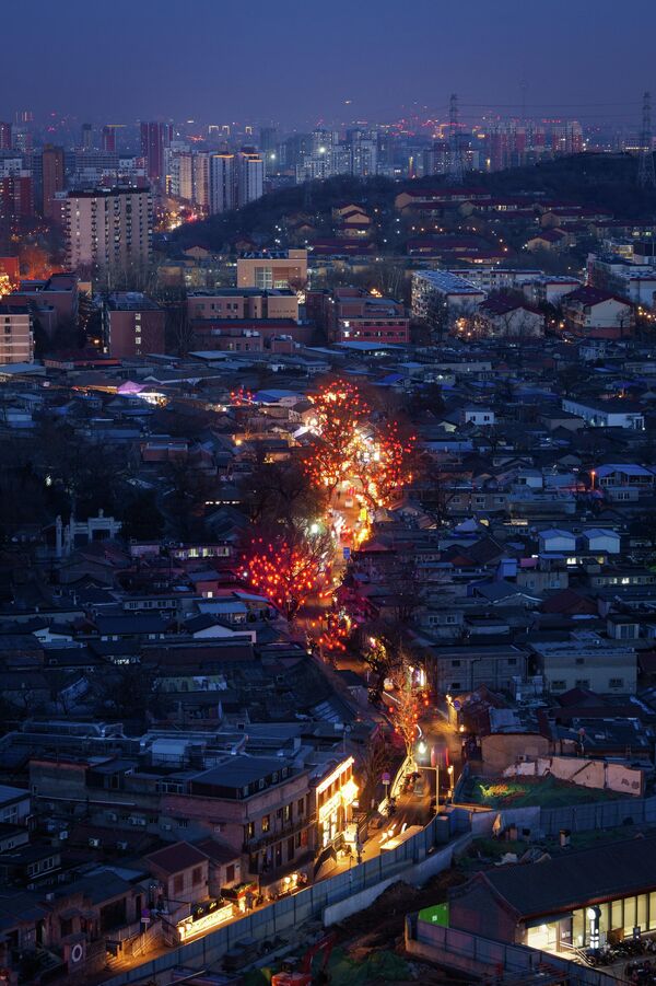 Городские огни освещают улицу, украшенную красными фонарями в преддверии новогодних праздников по лунному календарю. - Sputnik Таджикистан