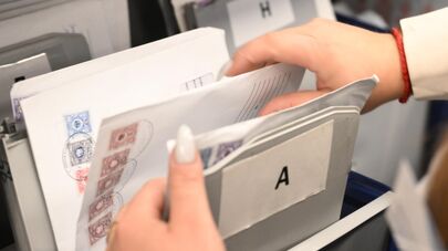 Сотрудница раскладывает письма в отделении "Почты России" в Москве.