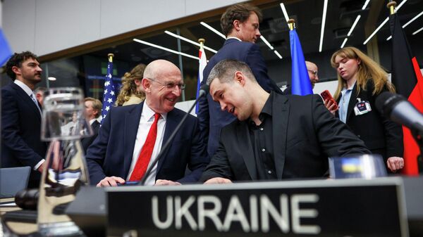 Министр обороны Великобритании Джон Хили беседует с министром обороны Украины Михаилом Федоровым во время заседания Контактной группы по обороне Украины в штаб-квартире Альянса в Брюсселе, Бельгия, 12 февраля 2026 года.  - Sputnik Таджикистан