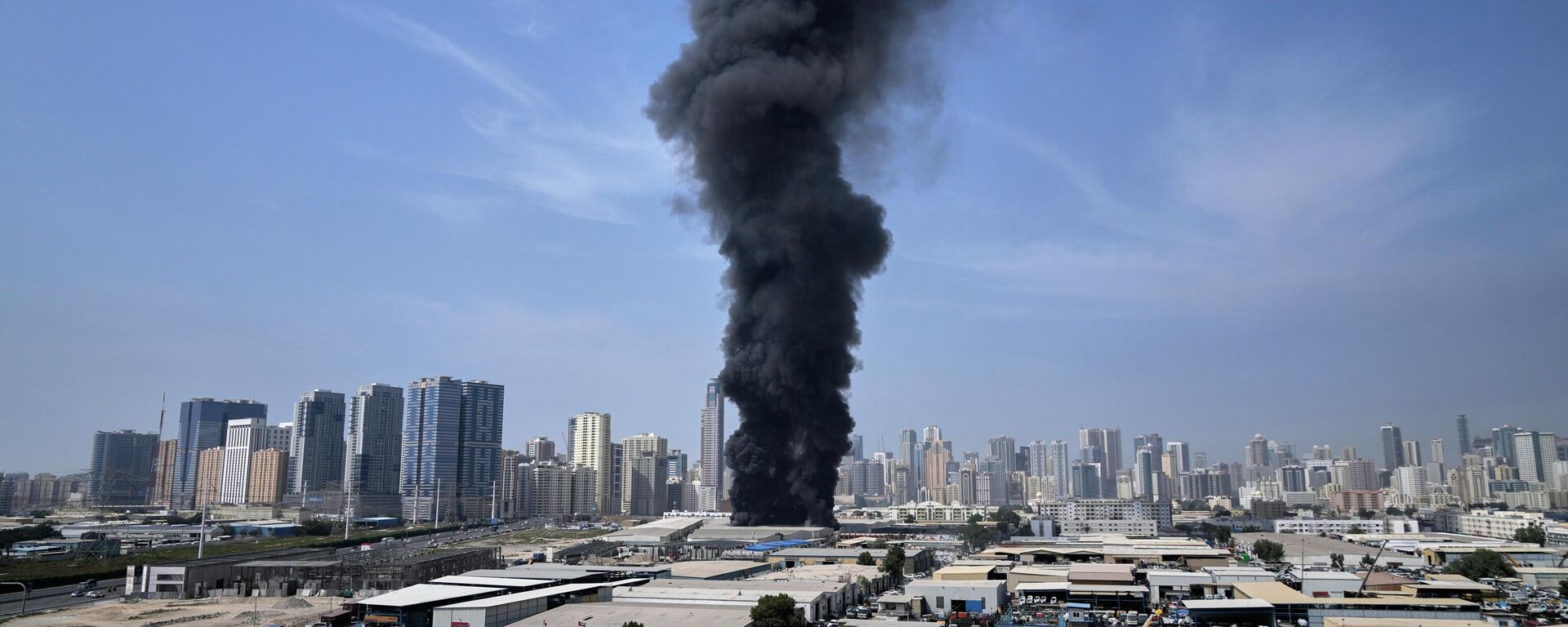 Столб дыма поднимается над складом в промышленной зоне города Шарджа в Объединенных Арабских Эмиратах после иранских ударов в Дубае, Объединенные Арабские Эмираты, воскресенье, 1 марта 2026 года. - Sputnik Тоҷикистон, 1920, 02.03.2026