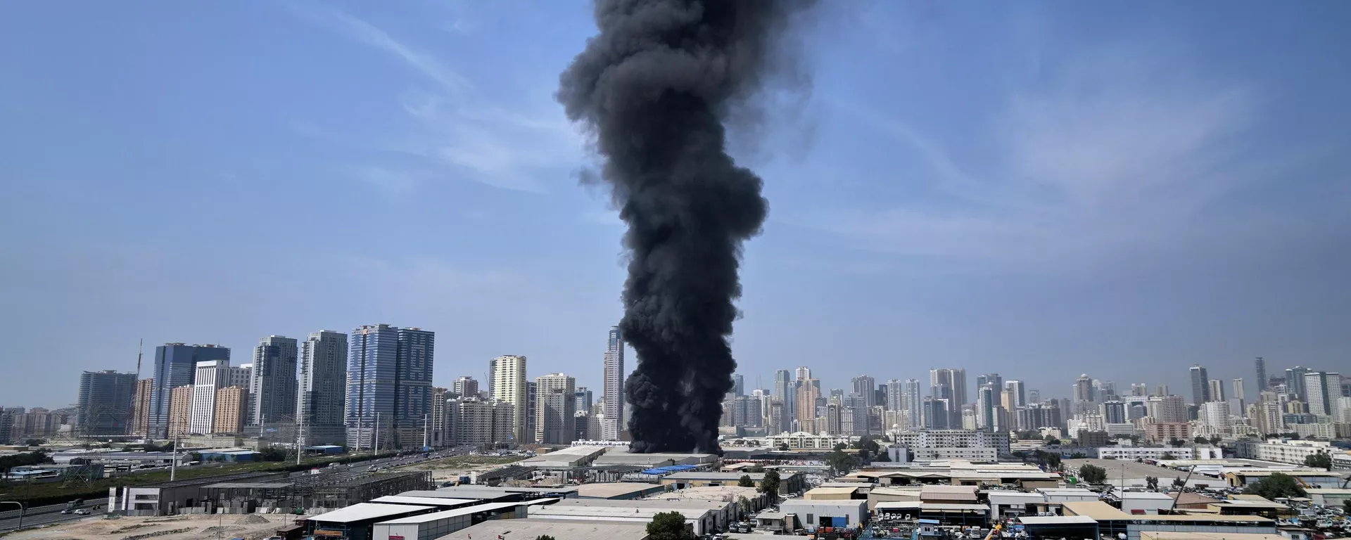 Столб дыма поднимается над складом в промышленной зоне города Шарджа в Объединенных Арабских Эмиратах после иранских ударов в Дубае, Объединенные Арабские Эмираты, воскресенье, 1 марта 2026 года.  — Sputnik Таджикистан, 1920, 02.03.2026