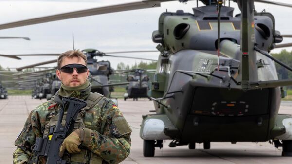 Военный полицейский стоит перед вертолетами ВВС Германии во время военных учений НАТО Griffin Lightning 2025, 6 мая 2025 года.  - Sputnik Таджикистан