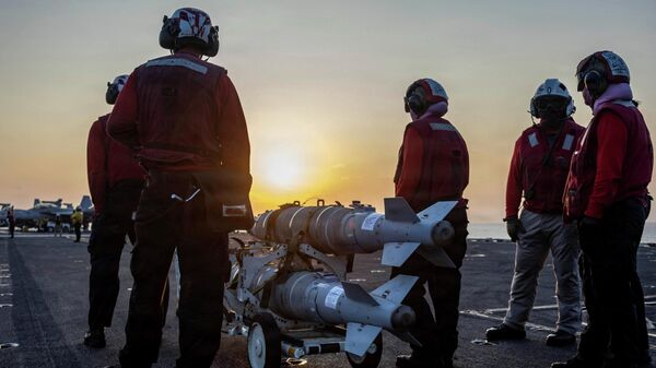 Моряки ВМС США готовят боеприпасы на полетной палубе авианосца Abraham Lincoln в рамках операции Эпическая ярость по атаке на Иран, 4 марта 2026 года. - Sputnik Таджикистан
