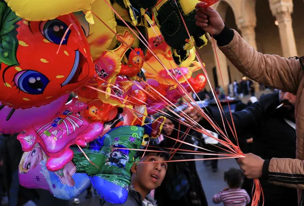 Мальчик рассматривает воздушные шарики, продаваемые торговцем, в то время как верующие собираются у мечети Мухаммеда аль-Амина после молитвы по случаю Ид аль-Фитр, знаменующей окончание священного месяца Рамадан, после эскалации конфликта между Хезболлой и Израилем на фоне американо-израильского конфликта с Ираном, в Бейруте, Ливан — Sputnik Таджикистан