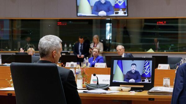 Владимир Зеленский выступает перед лидерами ЕС по видеосвязи во время круглого стола на саммите ЕС в Брюсселе в четверг, 19 марта 2026 года.  - Sputnik Тоҷикистон