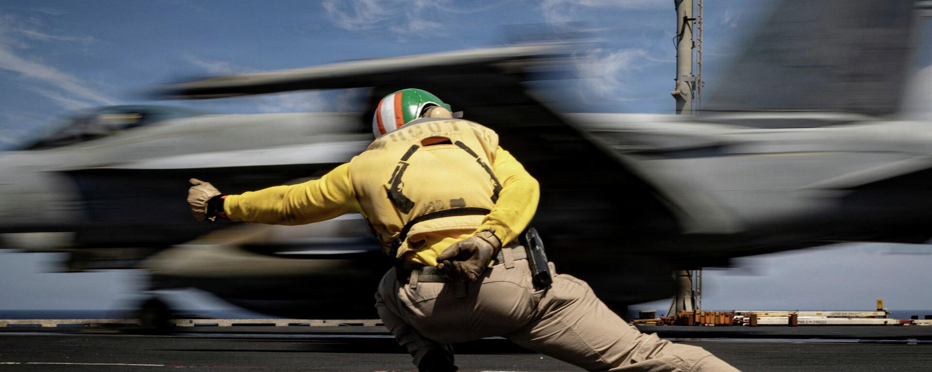 Моряк ВМС США подает сигнал к запуску истребителя во время операции Эпическая ярость по атаке на Иран 16 марта 2026 года. - Sputnik Тоҷикистон, 1920, 26.03.2026