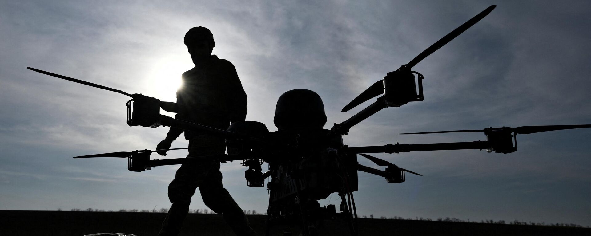 Военнослужащий 422-го полка беспилотных систем идет рядом с тяжелым ударным беспилотником на полигоне в Запорожской области. - Sputnik Таджикистан, 1920, 31.03.2026