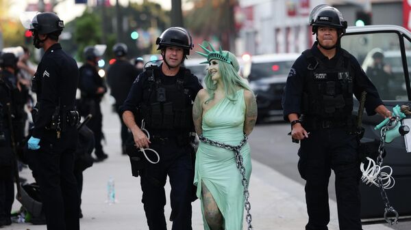 Полиция арестовала протестующую, одетую в костюм Статуи Свободы, в центре Лос-Анджелеса после митинга Нет королям - Sputnik Таджикистан