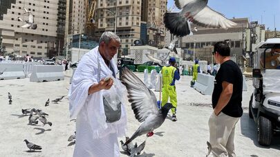 Мусульманский паломник кормит голубей возле Большой мечети во время ежегодного паломничества хадж в Мекку, Саудовская Аравия, во вторник, 3 июня 2025 года.