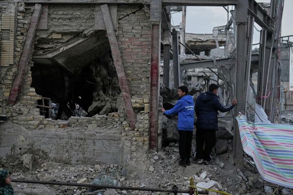 Ду мард бинои харобшударо дар маҷмааи Ҳусейниёи Гранд нигоҳ доранд - Sputnik Тоҷикистон