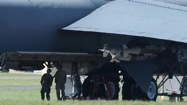Военнослужащие ВВС США возле бомбардировщика B-52 Stratofortress, загруженного боеприпасами, на авиабазе Королевских ВВС Фэрфорд, Великобритания, 7 апреля 2026 года.  - Sputnik Таджикистан