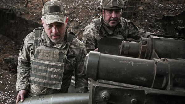Военнослужащие 260-й Запорожской отдельной бригады территориальной обороны Вооруженных сил Украины заряжают 152-мм снаряд для гаубицы Д-20 на передовой линии фронта в Запорожской области, Украина, 9 апреля 2026 года.  - Sputnik Тоҷикистон