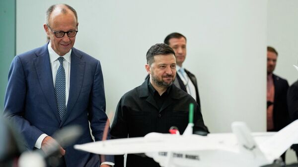 Канцлер Германии Фридрих Мерц и Владимир Зеленский наблюдают за презентацией беспилотников, созданных в рамках германо-украинского сотрудничества.  - Sputnik Тоҷикистон