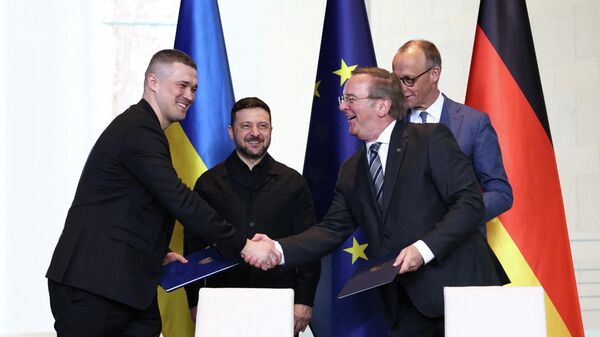 Канцлер Германии Фридрих Мерц, Владимир Зеленский, министр обороны Украины Михаил Федоров и министр обороны Германии Борис Писториус на церемонии подписания соглашения в рамках германо-украинских правительственных консультаций в Берлине, Германия, 14 апреля 2026 года. - Sputnik Таджикистан