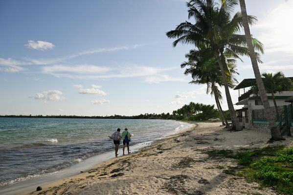 Одамон дар соҳили холӣ дар Плая Ларга. - Sputnik Тоҷикистон