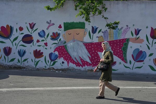 Прогулка женщины на фоне картины в Иране. - Sputnik Таджикистан