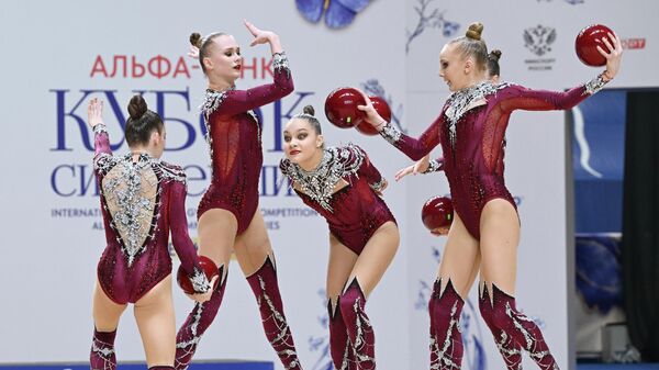 Спортсменки национальной команды субъектов Российской Федерации выполняют упражнения с пятью мячам в финале международных соревнований по художественной гимнастике Кубок Сильнейших-2026 в Казани. - Sputnik Тоҷикистон