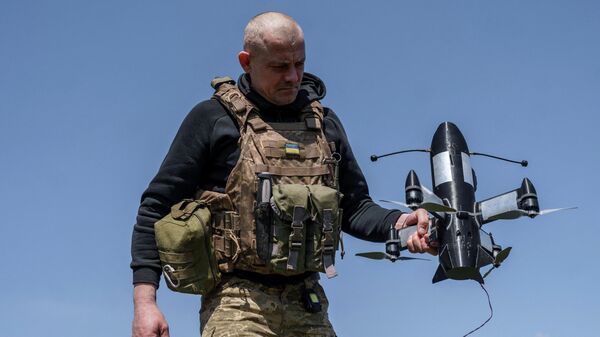 Военнослужащий подразделения ПВО 24-й отдельной механизированной бригады Вооруженных сил Украины готовит к запуску беспилотный летательный аппарат-перехватчик P1-Sun FPV, Донецкая область, Украина, 26 апреля 2026 года.  - Sputnik Таджикистан