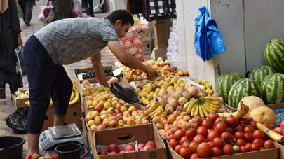 Продавец овощей и фруктов на рынке