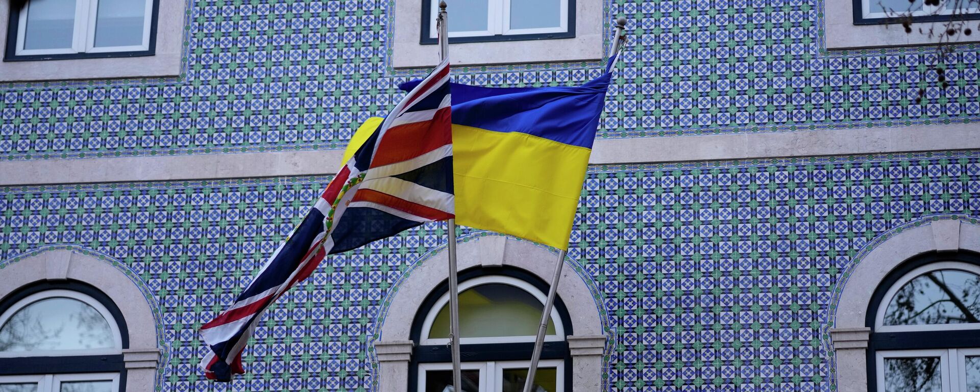Флаги Соединенного Королевства и Украины на балконе посольства Великобритании в Лиссабоне, 4 марта 2022 года. - Sputnik Таджикистан, 1920, 07.05.2026