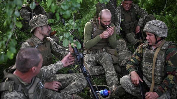 Новобранцы 118-й отдельной механизированной бригады Вооруженных сил Украины отдыхают во время военных учений вблизи линии фронта, Запорожская область, Украина, 21 мая 2026 года.  - Sputnik Тоҷикистон