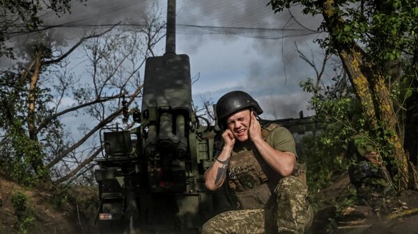 Военнослужащий 44-й отдельной артиллерийской бригады Вооруженных сил Украины стреляет из самоходной гаубицы 2С22 Богдана по российским позициям в Запорожской области, Украина, 25 мая 2026 года.  - Sputnik Таджикистан