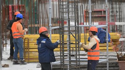 Рабочие вяжут арматуру на строительной площадке в Москве.