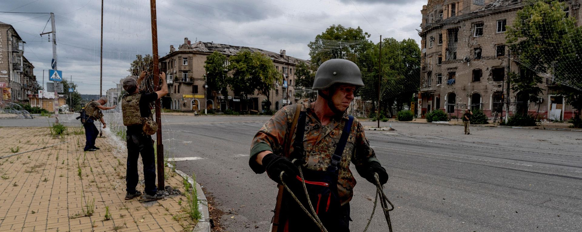 Военнослужащие Вооруженных сил Украины ремонтируют сети противодействия беспилотникам в прифронтовом городе Дружковка, Украина, 25 июля 2026 года. - Sputnik Таджикистан, 1920, 27.07.2026
