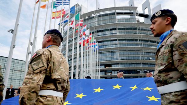 Военнослужащие держат флаг Европейского союза перед зданием Европейского парламента в Страсбурге. - Sputnik Тоҷикистон