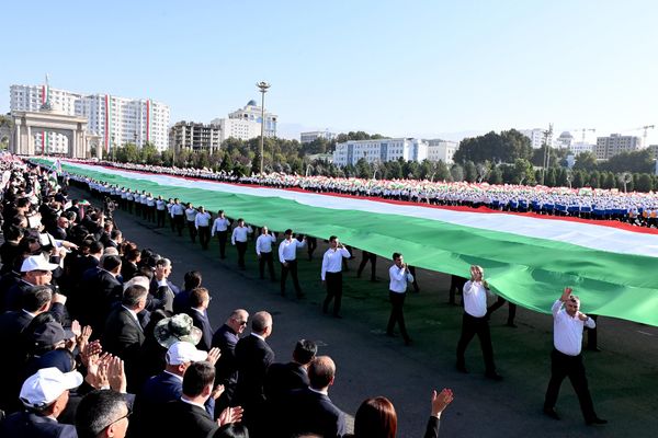 Граждане Таджикистана растянули государственный флаг страны во время праздничного шествия. - Sputnik Таджикистан