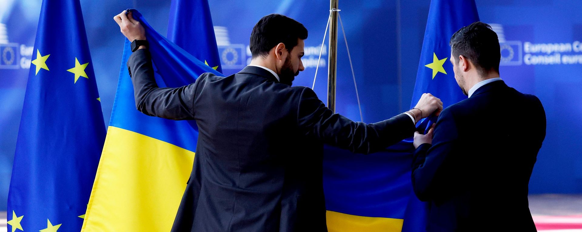 Сотрудники протокольной службы устанавливают флаг Украины перед саммитом ЕС в здании Европейского совета в Брюсселе, четверг, 6 марта 2025 года. - Sputnik Таджикистан, 1920, 09.09.2026