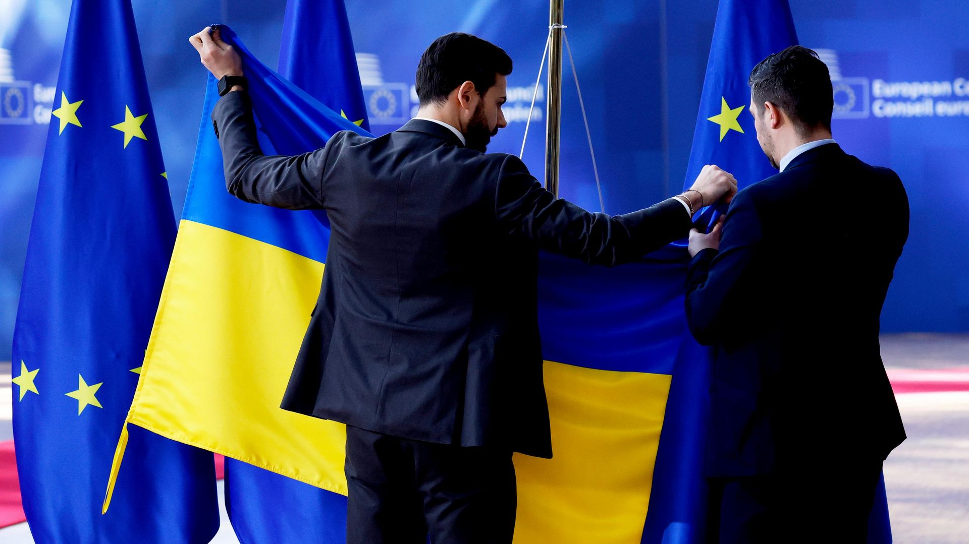 Сотрудники протокольной службы устанавливают флаг Украины перед саммитом ЕС в здании Европейского совета в Брюсселе, четверг, 6 марта 2025 года. - Sputnik Таджикистан, 1920, 09.09.2026